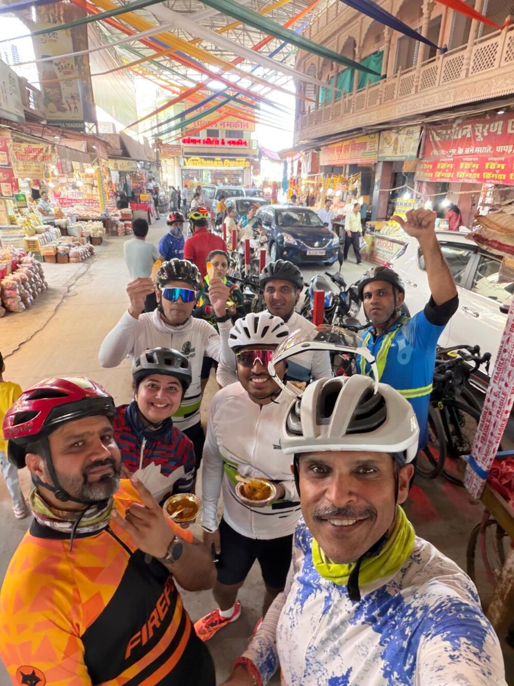 Riders taking a selfie in the busy market with food in hand