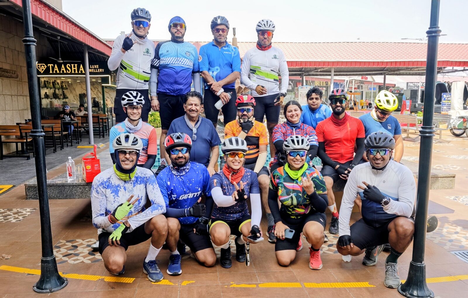 The whole group of cyclists posing together, some kneeling in front